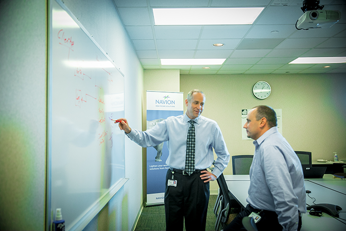 John Peasley & a Navion employee at a whiteboard looking at data